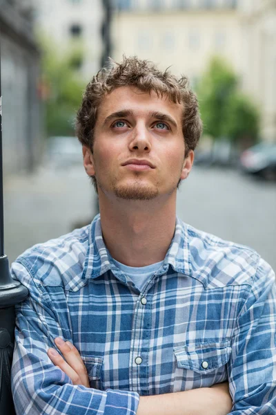 Joven con camisa a cuadros parado afuera — Foto de Stock