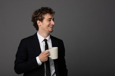 gri arka plan üzerine bir fincan ile takım elbiseli şık adam