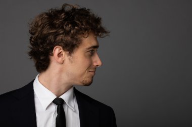 gri arka plan üzerine bir fincan ile takım elbiseli şık adam