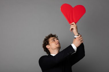 bir kalp elinde tutan shuit yakışıklı adam