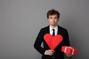 bir kalp elinde tutan shuit yakışıklı adam