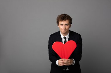 bir kalp elinde tutan shuit yakışıklı adam