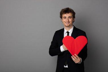 bir kalp elinde tutan shuit yakışıklı adam