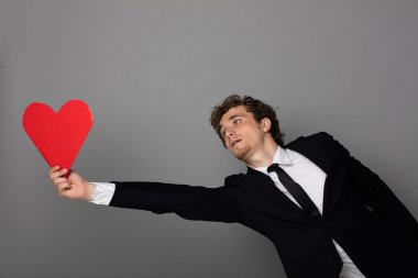 bir kalp elinde tutan shuit yakışıklı adam