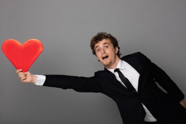 bir kalp elinde tutan shuit yakışıklı adam