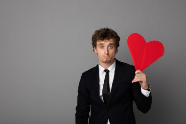 bir kalp elinde tutan shuit yakışıklı adam