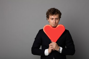 bir kalp elinde tutan shuit yakışıklı adam