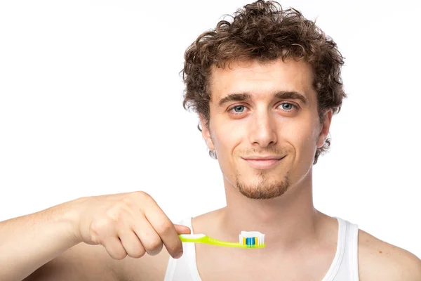 Curly guy brushing his teeth — Stock Photo, Image