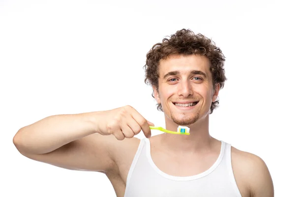 Krullend kerel zijn tanden poetsen — Stockfoto