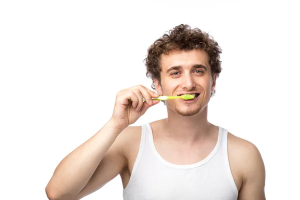 Curly guy brushing his teeth — Stock Photo, Image