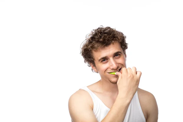 Curly guy brushing his teeth — Stock Photo, Image