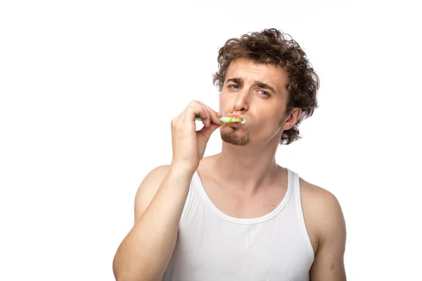 Curly guy brushing his teeth — Stock Photo, Image