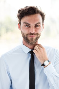 büyük bir pencere yanında duran işadamı