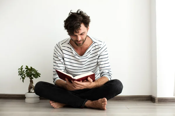 Adam bir kitap okuma ve katta duran — Stok fotoğraf