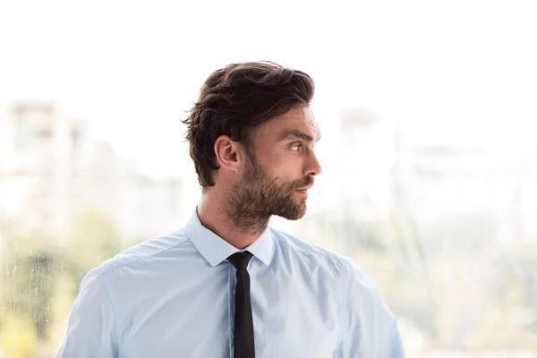 Businessman standing next to a big window — Stock Photo, Image