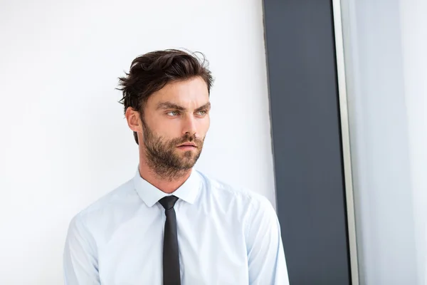 Geschäftsmann steht neben einem großen Fenster — Stockfoto