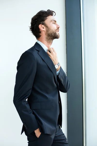 Businessman standing next to a big window — Stock Photo, Image