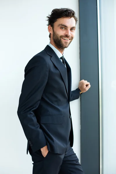 Businessman standing next to a big window — Stock Photo, Image