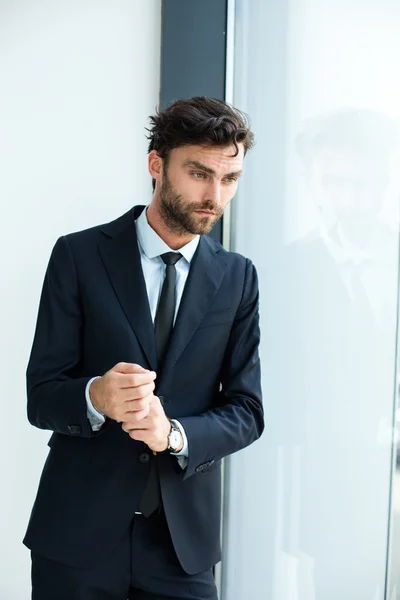 Businessman standing next to a big window — Stock Photo, Image