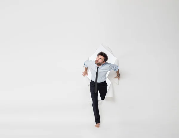 Office man with elegant outfit and tie breaking the paper backgr — Stock Photo, Image