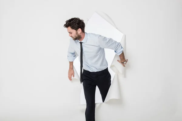 Office man with elegant outfit and tie breaking the paper backgr — Stock Photo, Image