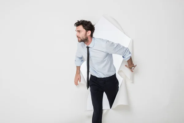 Hombre de oficina con traje elegante y corbata rompiendo el fondo de papel — Foto de Stock