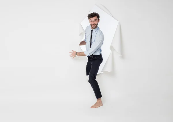 Muž s elegantní oblek a kravatu, lámání papírové pozadí — Stock fotografie