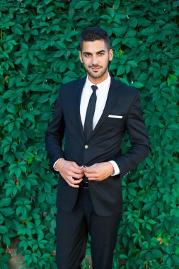 zarif işadamı yaprakları arka plan üzerinde duran