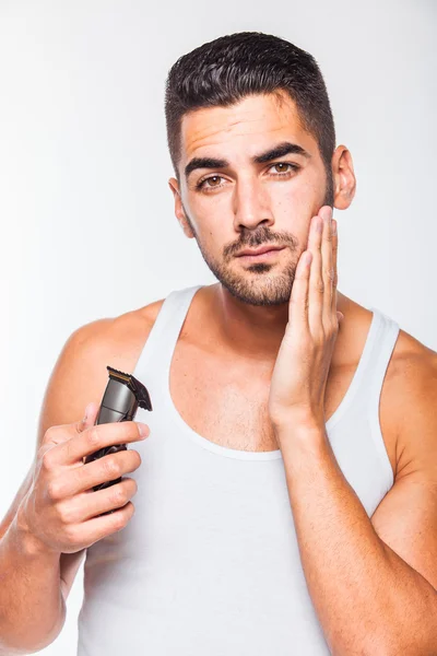 Jovem bonito homem aparando sua barba — Fotografia de Stock