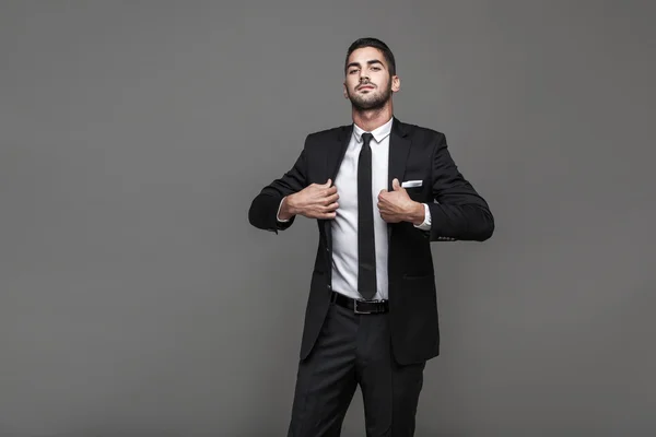 Hombre elegante guapo sobre fondo gris — Foto de Stock