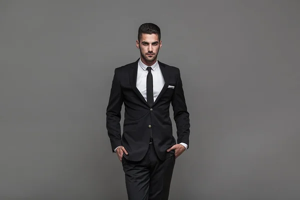 Hombre elegante guapo sobre fondo gris —  Fotos de Stock