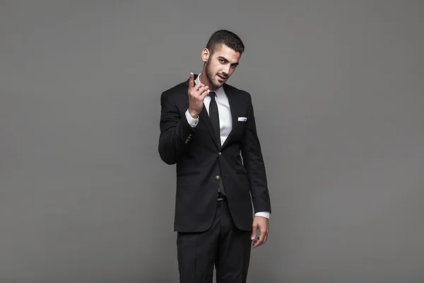 Hombre elegante guapo sobre fondo gris — Foto de Stock