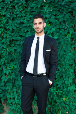 zarif işadamı yaprakları arka plan üzerinde duran