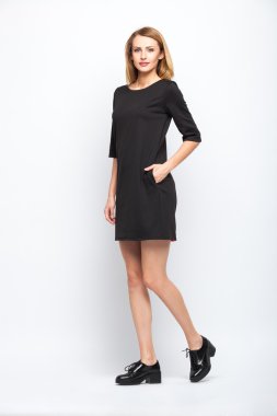 gri arka plan üzerinde duran güzel genç sarışın kadın