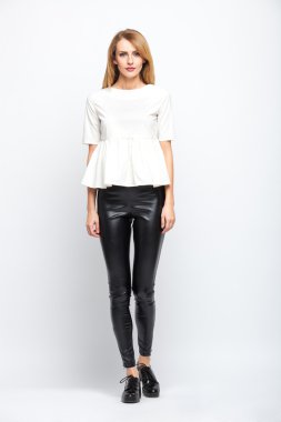 gri arka plan üzerinde duran güzel genç sarışın kadın