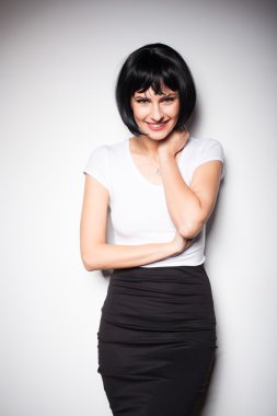 bir duvarın yanında ayakta çekici esmer kadın