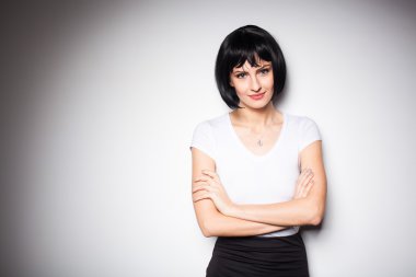 bir duvarın yanında ayakta çekici esmer kadın