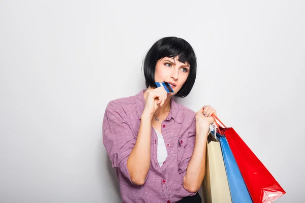 Jovem mulher bonita com cartão de crédito e sacos de compras — Fotografia de Stock