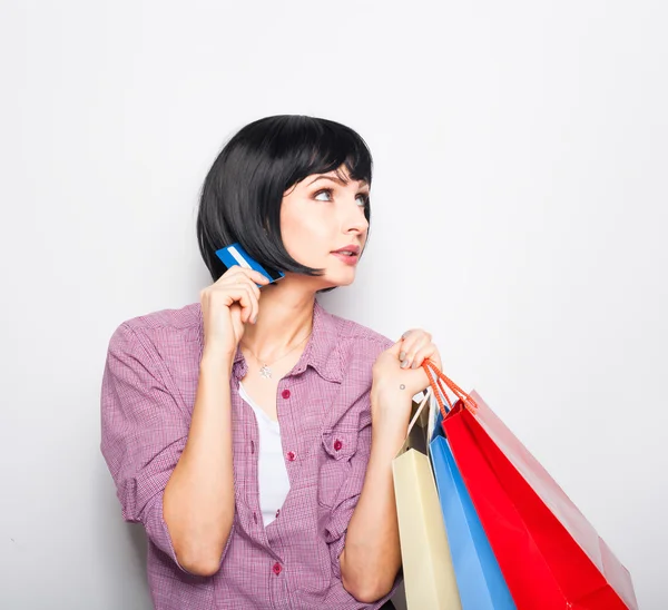 Jovem mulher bonita com cartão de crédito e sacos de compras — Fotografia de Stock