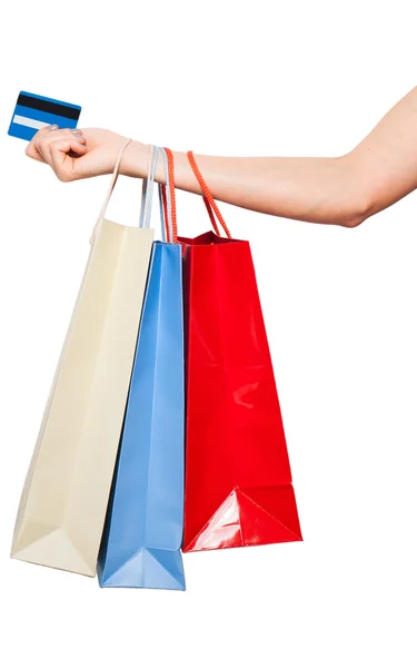 Mãos segurando sacos de compras coloridas no fundo branco — Fotografia de Stock