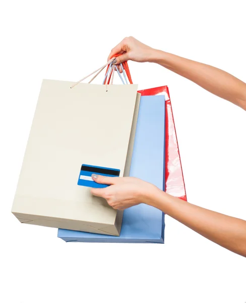 Mãos segurando sacos de compras coloridas no fundo branco — Fotografia de Stock