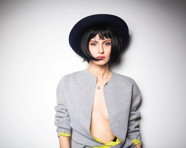 Modern woman with black hat on gray — Stock Photo, Image