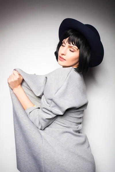 Modern woman with black hat on gray — Stock Photo, Image