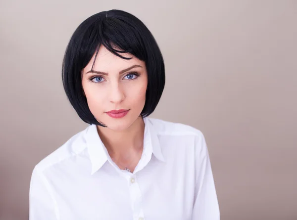 Brunette vrouw met blauwe ogen in wit overhemd geïsoleerd — Stockfoto