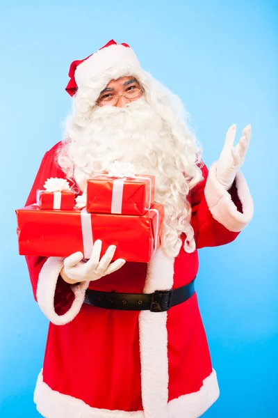 Kerstman met giften op handen op blauwe achtergrond — Stockfoto