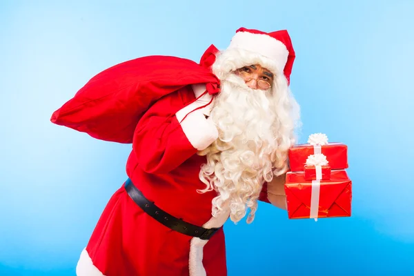 Babbo Natale con regali su mani su sfondo blu — Foto Stock