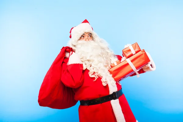 Babbo Natale con regali su mani su sfondo blu — Foto Stock