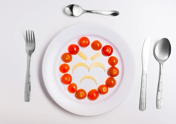板的滑稽表情符号与餐具白色衬底上制成食品 — 图库照片