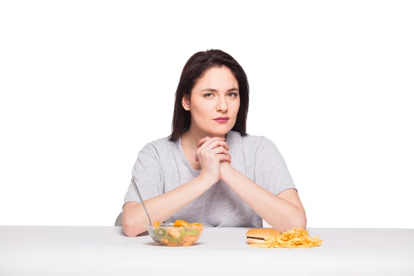 Foto de mulher com frutas e hambúrguer na frente em bac branco — Fotografia de Stock