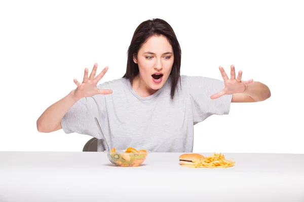 Picture of woman with fruits and hamburger in front on white bac — Stock Photo, Image